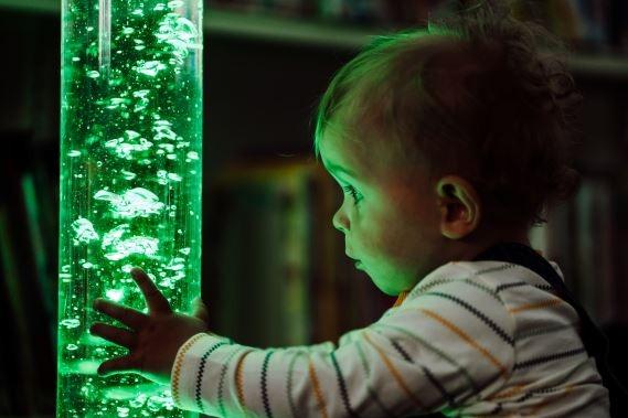 Jacob fascinated by the lamp at the Sensory Kids event in the Library.