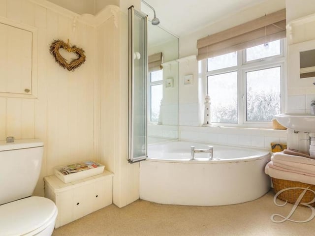 Sandwiched between two bedrooms at the back of the property is this stylish family bathroom. It boasts a corner bath with shower above, low-flush WC, wash hand basin and a window.