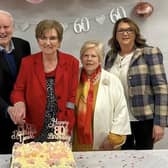Paddy and Susie Armour cutting the cake at their recent celebration marking their 60th wedding anniversary and Susie's 80th birthday. They were joined by their original bridal party line-up bridesmaid Bridie Devlin, bestman, Tommy Devlin, and flowergirl Mary McCloskey.