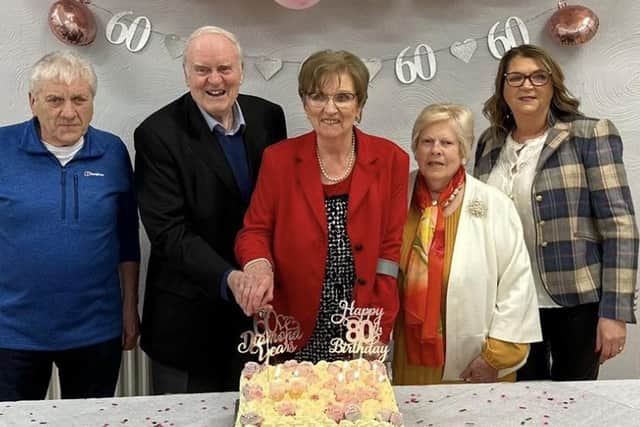 Paddy and Susie Armour cutting the cake at their recent celebration marking their 60th wedding anniversary and Susie's 80th birthday. They were joined by their original bridal party line-up bridesmaid Bridie Devlin, bestman, Tommy Devlin, and flowergirl Mary McCloskey.