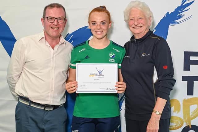 Hockey player Erin Pim from Anahilt received her Mary Peters Trust award certificate from Barry Funston and Lady Mary Peters. Pic credit: Mary Peters Trust