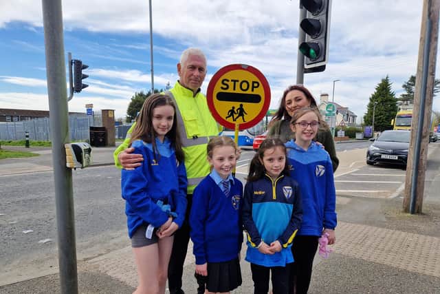 John the school crossing patrol man is to be moved from St Francis PS crossing by the Education Authority after the position was terminated. Charlene Curran and children from St Francis Primary School.