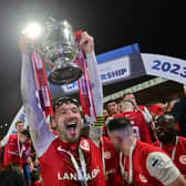 Larne skipper Tomas Cosgrove lifts the Gibson Cup.