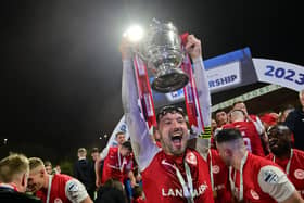 Larne skipper Tomas Cosgrove lifts the Gibson Cup.