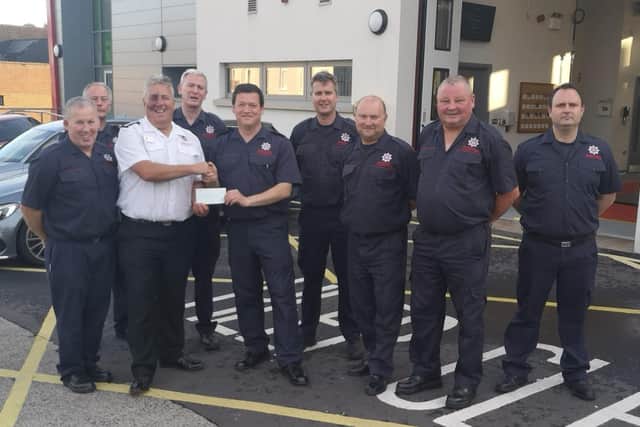 Firefighters presented a cheque for £2000 to Nigel McGuffin, Northern Ireland representative for the Fire Fighters' Charity, in April.  Photo: Alistair Carmichael