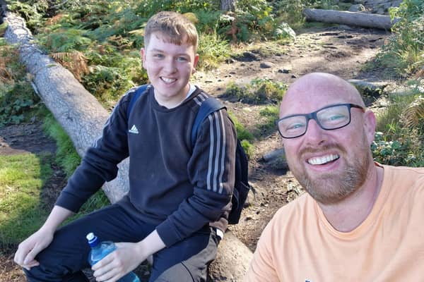 Father and son take a break during preparations for their 17-day trek.
