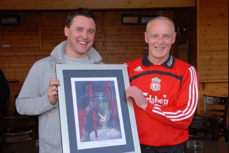 Darren Graham of the Olderfleet Liverpool Supporters' Club hands over a signed photograph from the PAC auction to Jim Maxwell in 2009. LT19-336-PR