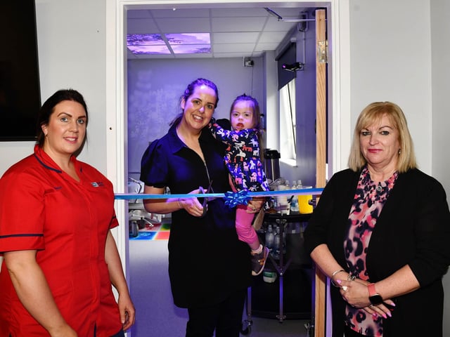 Lisa Barclay and Alison Cook look on as Fiona O'Neill cuts the ribbon to mark the official opening of the new Sensory Room with help from her daughter Gracie. CREDIT NHSCT