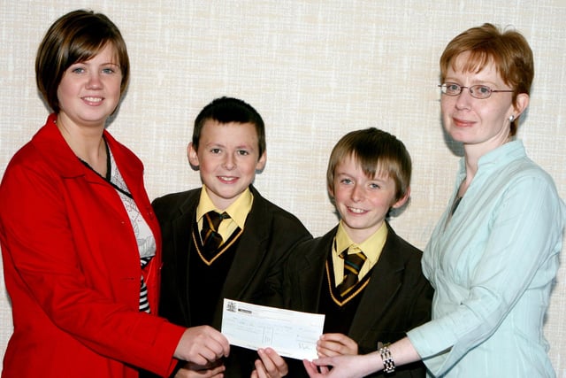 Alexander McAteer and Adam Mullan who donated their prize money from the Lammas Fair street entertainer competition in 2007 to Marie Curie, accepting the cheque is Helen McCambridge from Marie Curie and Una Hamill from Moyle District Council