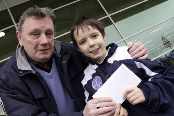 WALK THIS WAY.,,Johnny McCurdy, President of Ballymoney Utd Youth Academy, pictured in 2009, handing over a JJB Sports gift voucher to young Adrian Gilmore, who was the top fundraiser during a sponsored walk to raise funds for the Academy.