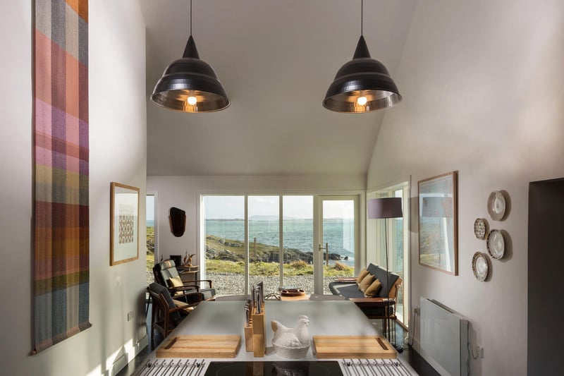 The kitchen has a dining area with more of the striking floor-to-ceiling windows that make the most of the coaastal vistas.