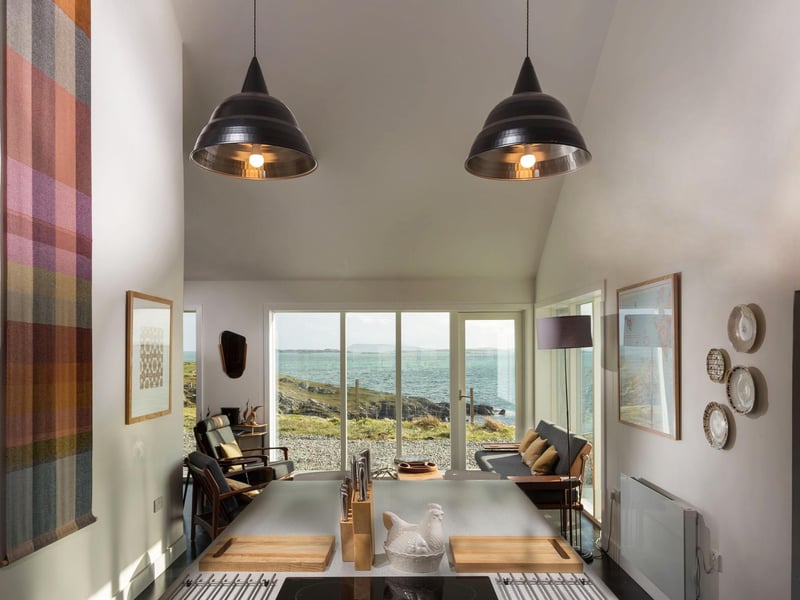 The kitchen has a dining area with more of the striking floor-to-ceiling windows that make the most of the coaastal vistas.
