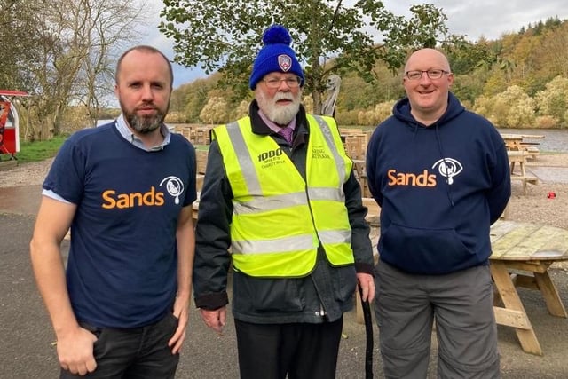 Representatives from SANDS NI welcome Davy across the finishing line