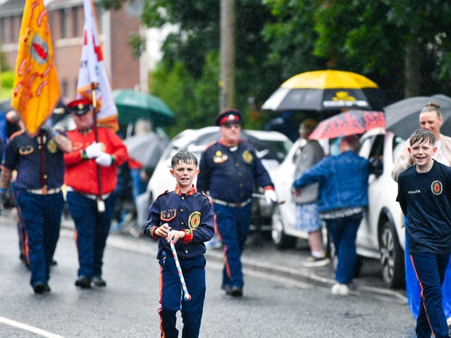 Young band members enjoy the parade despite the rain.