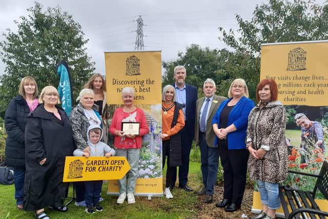 Trevor Edwards, Area Organiser of the National Garden Scheme of NI awarded a plaque plus a grant of £2k to Marie Cullen, Secretary of Taghnevan Allotments in Lurgan, Co Armagh. Pictured with them are Armagh, Banbridge and Craigavon Council Deputy Mayor Sorcha McGeown, Upper Bann Sinn Fein MLA John O'Dowd, Pat Mallon who is on the Taghnevan Allotments committee other members of the committee and allotment users.