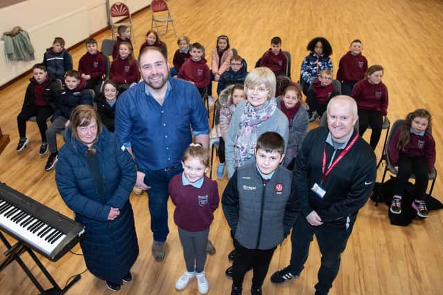 Pictured during a music class with children from St Malachy’s Primary school are Teacher Edward Gribben, group secretary Jacqueline Devlin, Housing Executive Patch Manager Niall McGurgan and Good Relations Officer Anne Marie Convery. Credit: Submitted