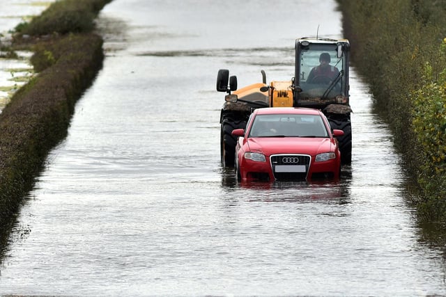A passing telehandler helps a stranded motorist who was stuck in flooding on the Portadown-Loughgall Road on Tuesday. PT44-248.