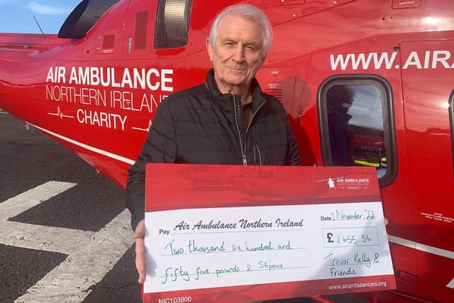 Trevor Kelly presents the money raised at a recent evening of entertainment to Air Ambulance NI