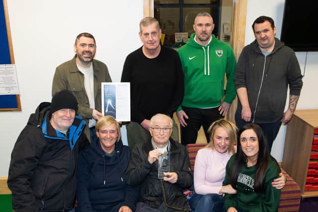 NIHE's good relations officer Stephen Gamble (back left) congratulates chairperson Seamus Kelly (front centre) and members of Bawnmore and District Residents' Association on winning runner-up in the housing estates category of the all-Ireland IPB Pride of Place Awards 2022.