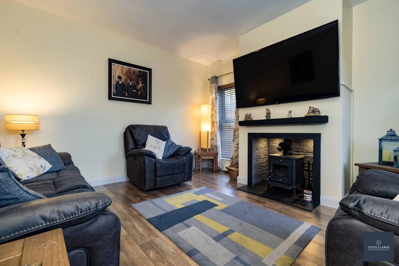 The lovely dual aspect living room has an attractive fireplace with a wood burning stove and slate hearth. Feature lighting completes the cosy atmosphere.