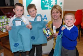 Ciara Burns, community energy worker with TADA gives reuseable bags and low wattage bulbs to St Mary's PS pupils Eoin McVeigh, Kevin O'Hagan and Danny McAllinden at the energy saving advice day in 2007.