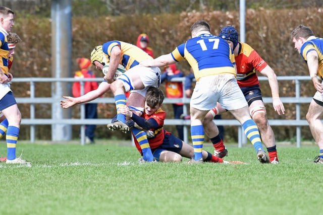 A Ballyclare player makes a tackle.