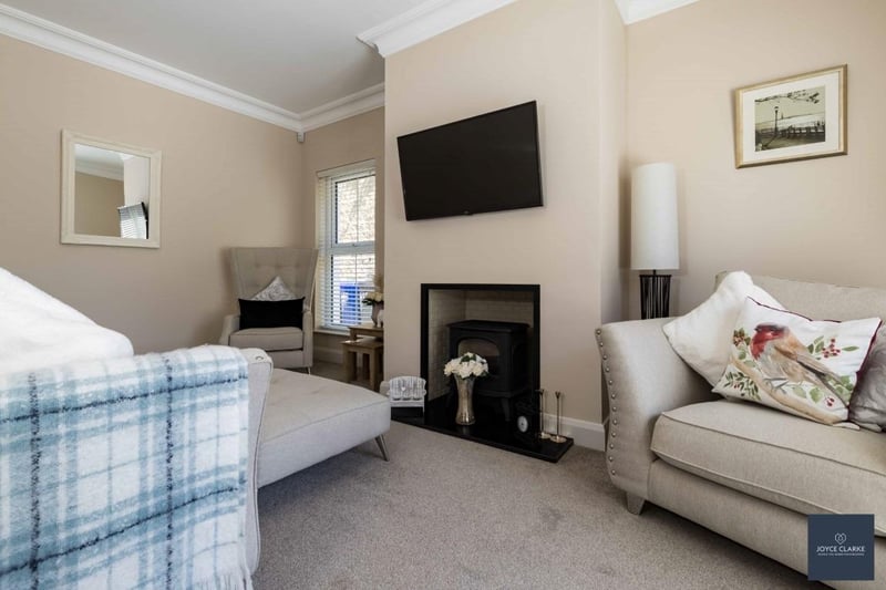 The tastefully decorated dual aspect reception room has a feature fireplace with gas stove, tiled chamber and hearth.