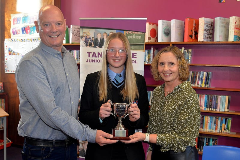 Leah Roney, winner of the Davison Cup for contribution to girls' hockey receives her trophy from sponsors Mr and Mrs Campbell and Allison Davison at the Tandragee Junior High School prize day. PT44-200.