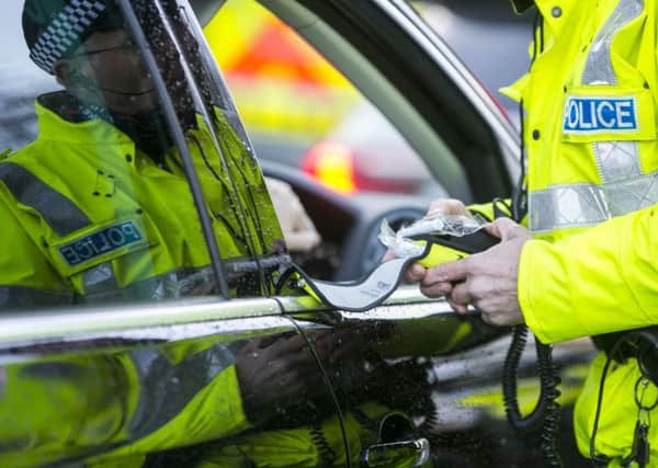 A PSNI Road Policing officer prepares a breathalyser test during a random drink driving checkpoint. (Liam McBurney/PA Wire)