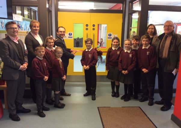 Mr John Reid (Governor), Ms Anne McDermott (Chair of Governors), Mrs Paula Cunningham (Principal) and Ald Billy DeCourcy along with the Pupils Council watch as the Mayor officially opens the newly refurbished foyer and play area in St Jamess Primary School.