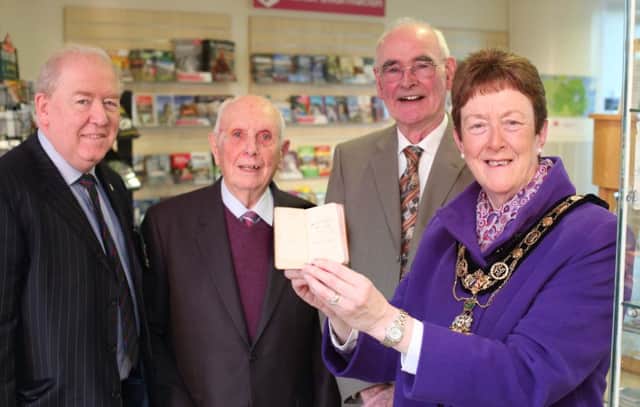 The Mayor of Causeway Coast and Glens Borough Council, Councillor Joan Baird OBE, holds the tiny pocket bible as Steven Chambers, Ernest Crawford and Laurence Chambers look on