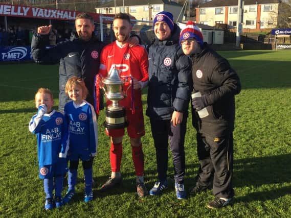 Hanover captain James Sergeant with the Bob Radcliffe Cup trophy. Also included are, back row from left, Steven Hyndes (manager), Dean Crowe (assistant manager) and Dean Wilson (team attendant), plus young fans Taylor Crowe (left) and Olly Hyndes.
