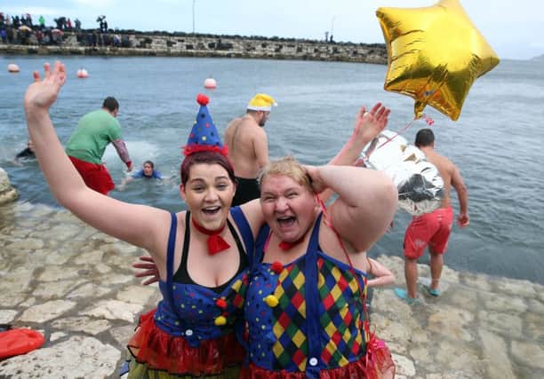 Megan and Angela McClements celebrate after taking the plunge into Carnlough harbour during the annual New Year's Day swim.  Picture: Pacemaker