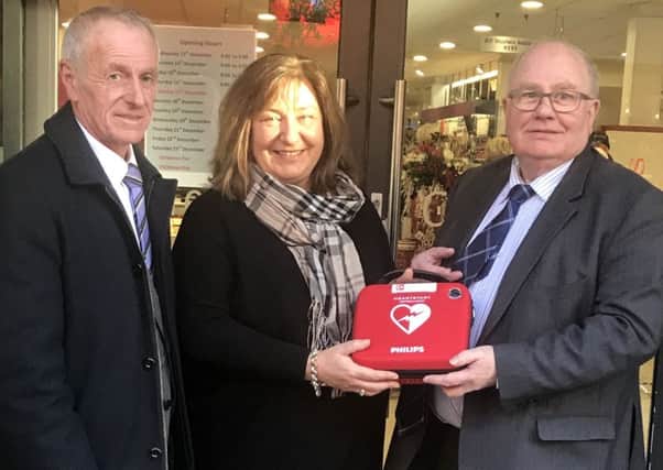 Eleanor McKay, Personnel Manager from Camerons Ballymena receives the defibrillator, provided by Ballymena BID subgroup, Safer Cleaner Accessible from William Alexander, Ballymena BID Director and Trevor Parker, Development Manager of Ballymena Retail Against Crime (BRAC).