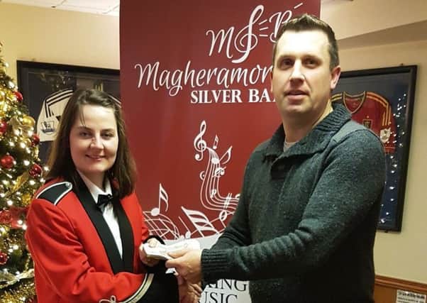 Duncan Gallagher, Club Steward of Larne Tech. Old Boys, hands over a cheque for Â£750 to Ariane Matthews, chairperson of Magheramorne Silver Band, in aid of the bands chosen charity, the Northern Ireland Childrens Hospice. (Submitted Pic).