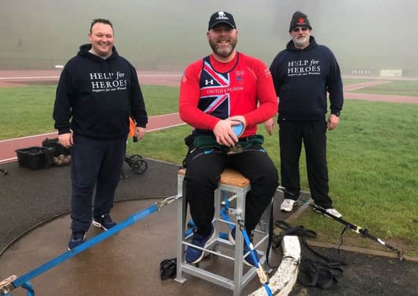 Lisburn man Dougie Durrant (right) and fellow veterans Chris Mack and Aaron Lorimer (left) try out the new throwing chair at the Mary Peters Track. The new piece of equipment, donated by Lagan Valley Steel, will be kept at the track for use by other athletes with disabilities.