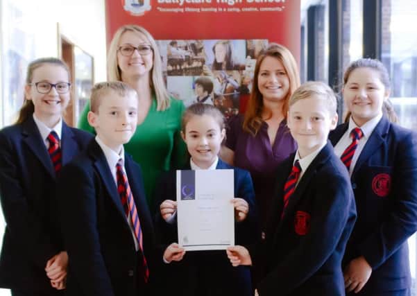 Gill Fairly, Investors in People Practitioner (back left), is pictured presenting the award to Year Eight pupils and biology teacher, Nikki Craig (back right).