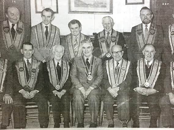 Six members of LOL 207 were presented with fifty year medals at Lisburn Orange Hall in 1980. Pictured with them are others members of the lodge and district officers.