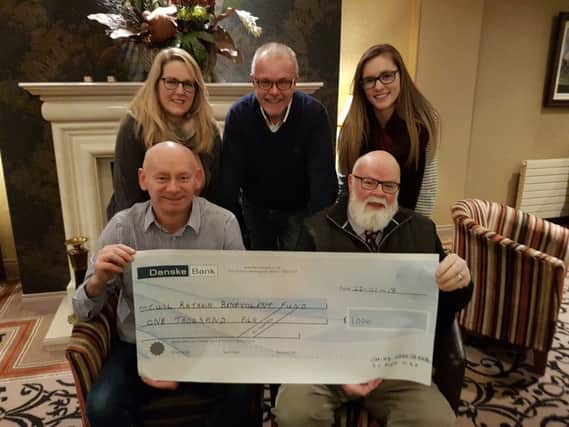 Davy Boyle MBE presents a cheque for Â£1,000 to the Cuil Rathain Benevolent Fund. Back row are Rosie Dickie, Hanna Reid and Q Radio presenter Denis McNeill. Front row left, David Rankin, trustee.