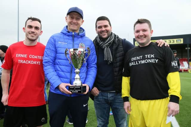 Nicky Coates and Sammy Clingan, the captain and manager of the Short Circuit team and David Healy and Gary Dunlop of the Road Racers team, share the trophy after a 1-1 draw in the Road Racers v Short Circuit bike racers charity football match at Seaview on Sunday.  PICTURE BY STEPHEN DAVISON