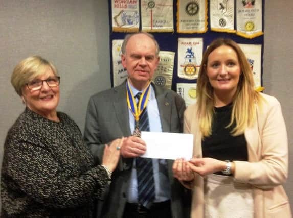 Diane Strain and Dawn Weir of Action Cancer receiving a cheque from
Carrickfergus Rotary President Jim Dunlop.