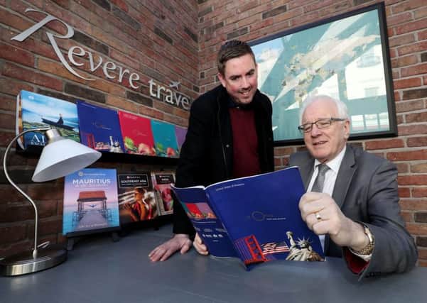 Chairman of Lisburn and Castlereagh City Council's Development Committee, Alderman Allan Ewart MBE (right), checks out the latest holiday offers from Michael Preedy, proprietor of the newly-opened Revere Travel, Lisburn Square.