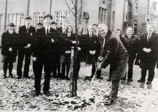 Lurgan College pupils Simon Hamilton helps Rotary Club president  Tom Canning to plant a tree in the school grounds. The club was supporting the school's conservation efforts