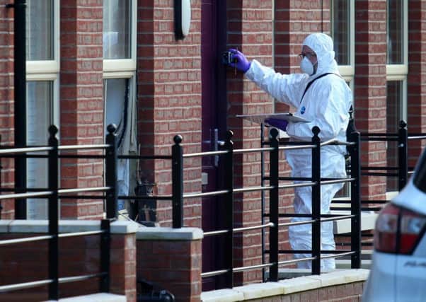 A PSNI forensics officer assesses the scene of the pipe bomb attack at Mill Street, Hilden. Pic by Pacemaker