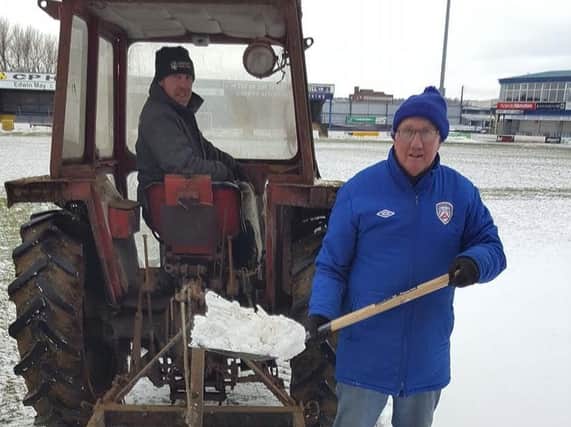 Coleraine ggroundsman Tommy Docherty worked hard on Friday to clear the pitch with the help of Ian McClelland.