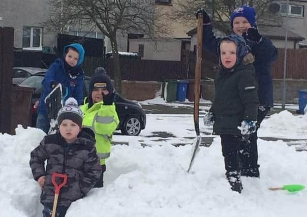 Lewis, Alfie, Bobby and George Stronge and their friend Rhys Tate clearing snow for their neighbours at Campbell Court, Maze.