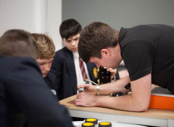 A member of the Yelo team demonstrating soldering to pupils.