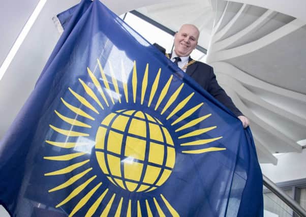 Mayor of Mid and East Antrim, Cllr Paul Reid pictured holding the Commonwealth Flag.