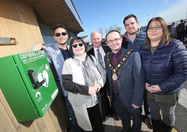 The Mayor, Cllr Paul Hamill launches the new defibrillator at Jordanstown Loughshore Park with Cllr Maguire, Richard Lutton, Mark, Janice and Victoria Stone.
