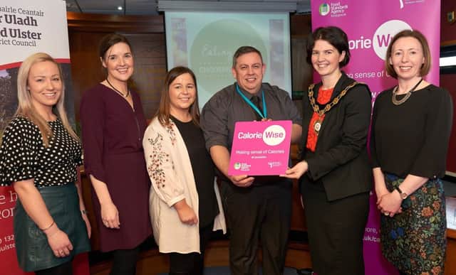 Mark Irvine, Support Services Manager at Mid Ulster Hospital, is pictured receiving his Calorie Wise Award from the Chair of Mid Ulster District Council, Councillor Kim Ashton. Also pictured, (l-r) are: Louise begs, Food Standards Agency; Monica Mc Donnell and Claire Mc Allister, Mid Ulster District Council and Fionnuala Close, Food Standards Agency.